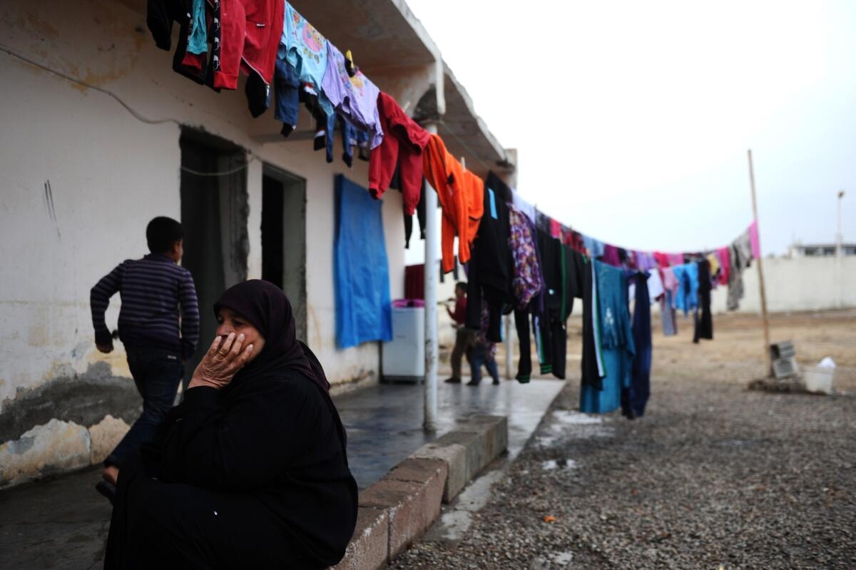 A Syrian woman sits in front of her house in a refugee camp in Reyhanli, Turkey, near a border crossing with Syria, on January 15, 2014.