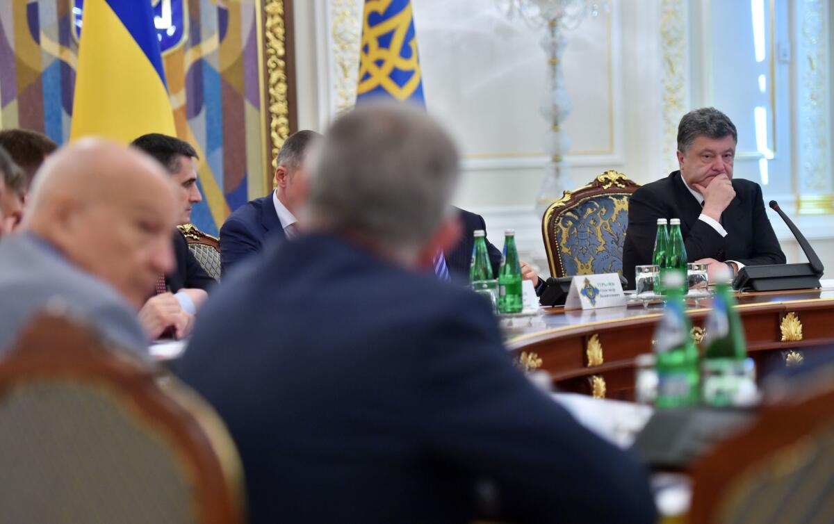 Ukrainian President Petro Poroshenko, right, chairs an emergency meeting of the country's National Security and Defense Council, called after Russia sent two armored columns across the border.
