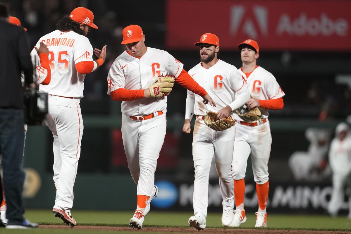 San Francisco Giants' Brandon Crawford, left, celebrates with Joc Pederson, Luis Gonzalez and Mike Yastrzemski after the Giants defeated the Kansas City Royals in a baseball game in San Francisco, Tuesday, June 14, 2022. (AP Photo/Jeff Chiu)
