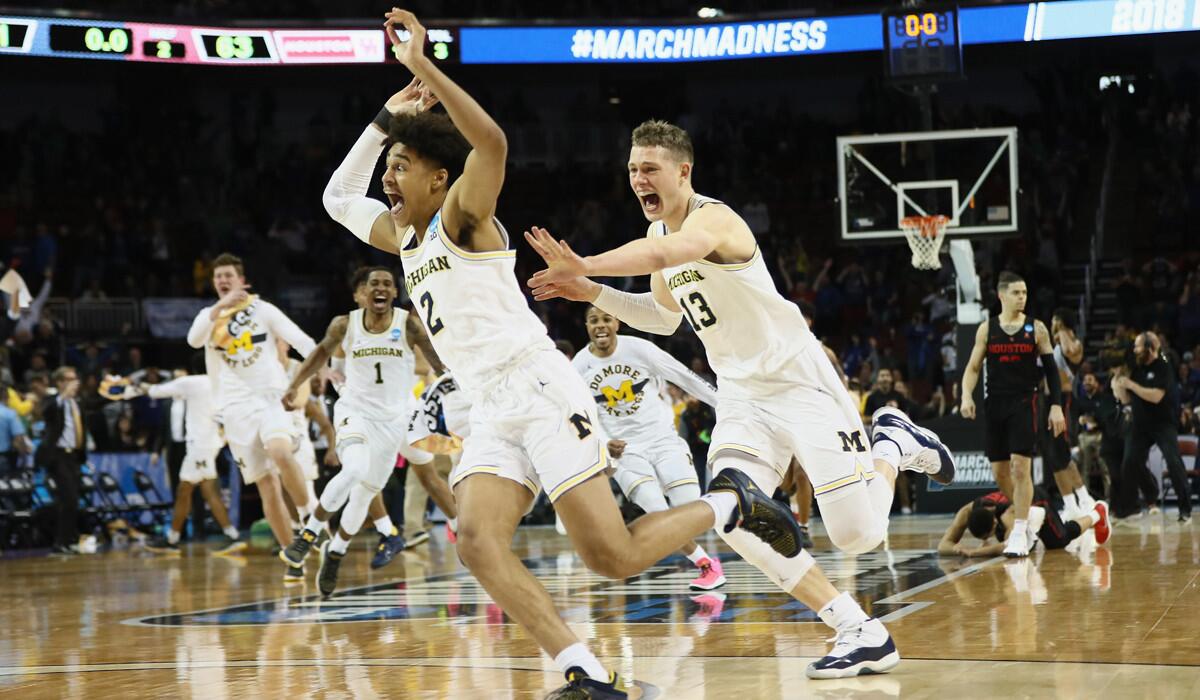 Michigan's Jordan Poole (2) and Moritz Wagner (13) celebrate Poole's three-point buzzer beater over Houston.