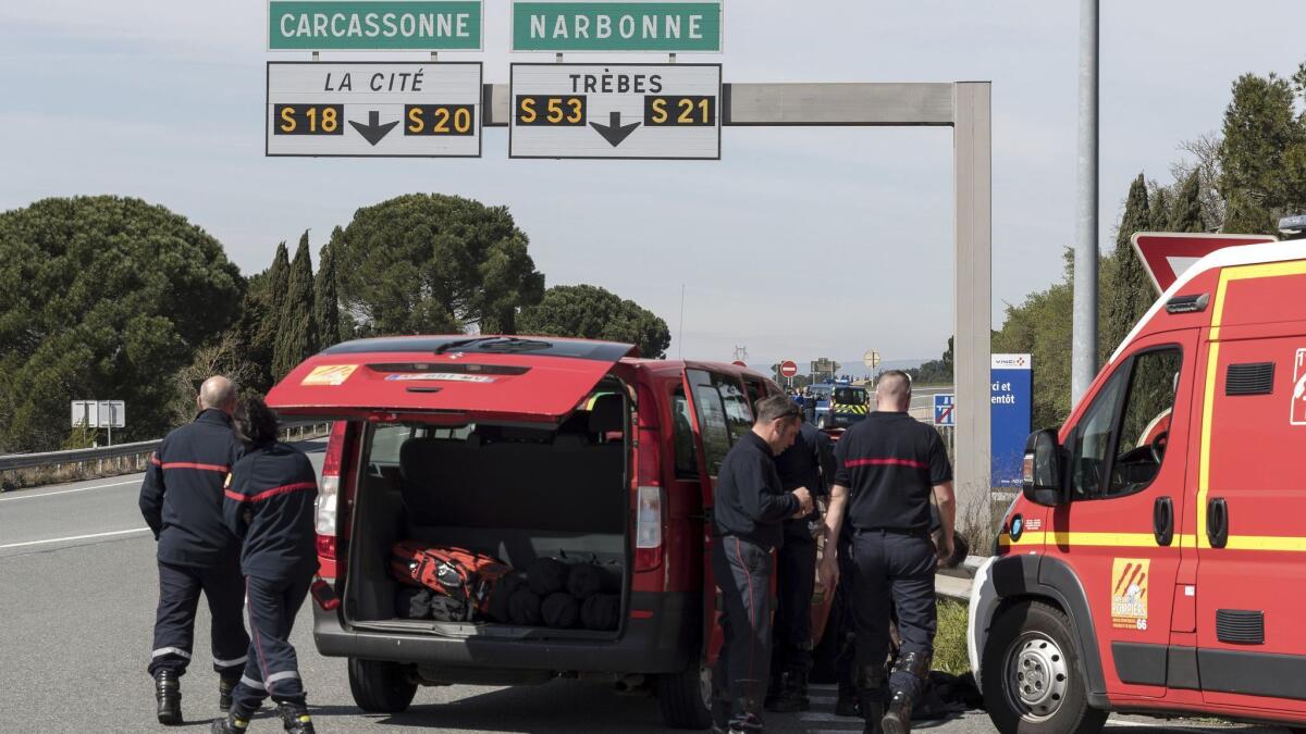 French police and firefighters secure the entrance to the town of Trebes, in southern France, where an armed man took hostages in a supermarket.