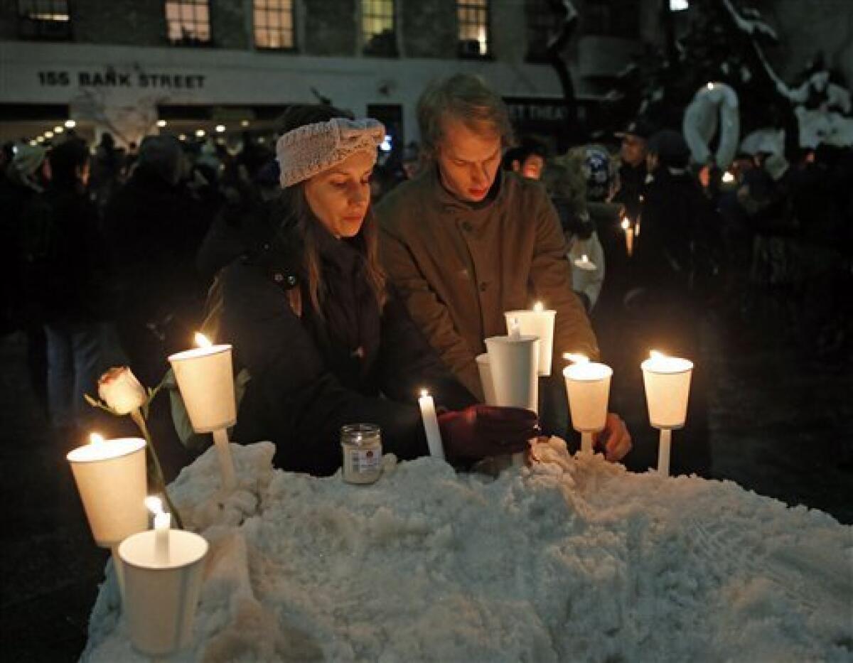 Candles adorn a snowbank after a vigil for actor Philip Seymour Hoffman at the Bank Street Theater in New York City.