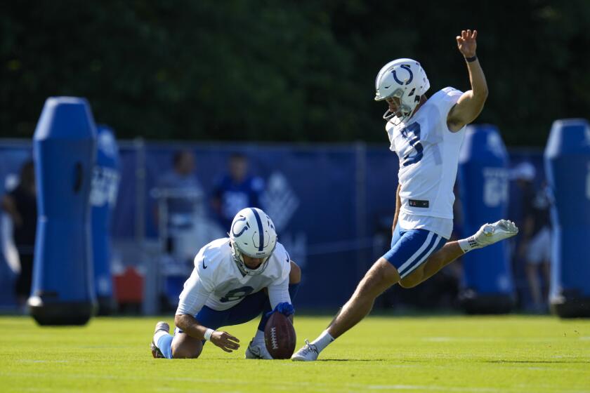 The Colts' Lucas Havrisik kicks from the hold of Rigoberto Sanchez during camp in July.