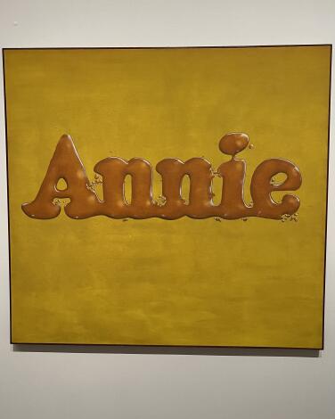 An Ed Ruscha painting that consists of the single word Annie that looks poured from maple syrup