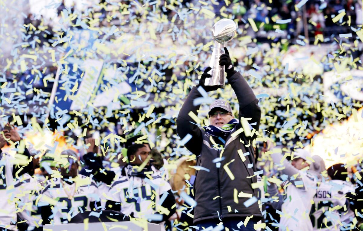 Seattle Seahawks owner Paul Allen lifts the Vince Lombardi Trophy during a rally in Seattle. The Seahawks defeated the Denver Broncos in NFL football's Super Bowl XLVIII game in East Rutherford, N.J.
