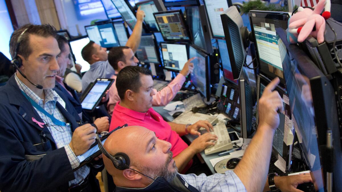 Members of Livermore Trading Group monitoring stock prices at the New York Stock Exchange on July 22.