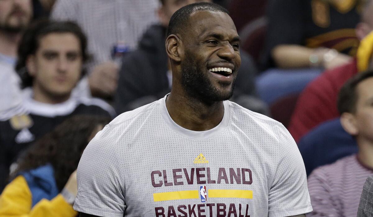 Cleveland Cavaliers' LeBron James laughs as he sits on the bench in the first half of an NBA game against the Dallas Mavericks on Wednesday.