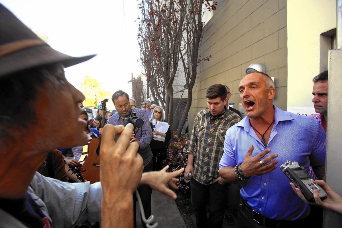 Mark Lipman, left, of the activist group People Organized for Westside Renewal, argues with vacation rental operator Sebastian de Kleer in Venice.