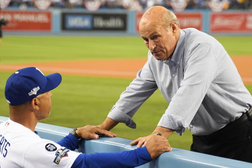 LOS ANGELES, CALIFORNIA - OCTOBER 04: President and part-owner of the Los Angeles Dodgers, Stan Kasten, speaks to manager Dave Roberts #30 before the start of game two of the National League Division Series against the Washington Nationals at Dodger Stadium on October 04, 2019 in Los Angeles, California. (Photo by Harry How/Getty Images)