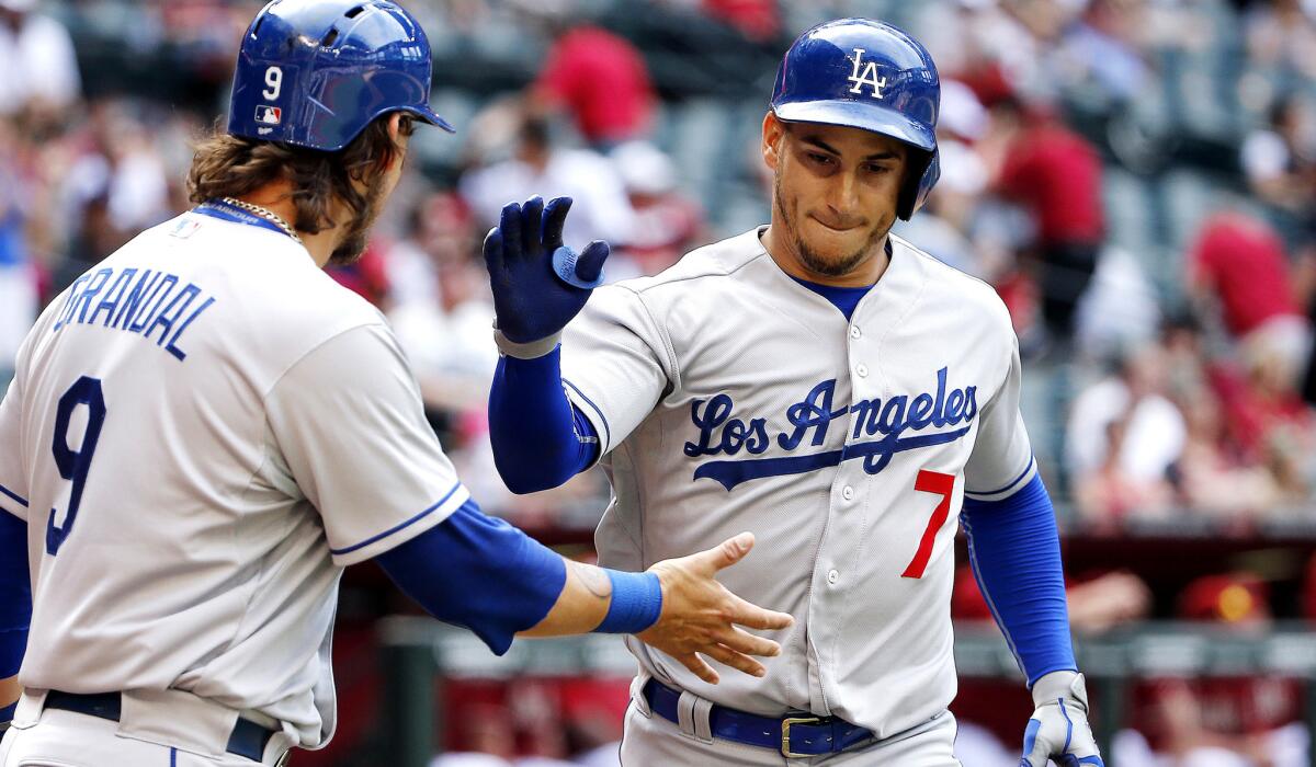 Dodgers third baseman Alex Guerrero (7) is congratulated by catcher Yasmani Grandal after hitting a two-run home run against the Diamondbacks in the ninth inning Sunday in Phoenix.