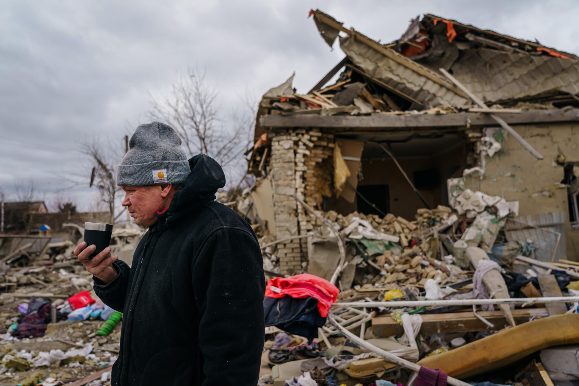 Igor Majayev looks over the remains of his home after an attack that killed his wife and daughter in Markhalivka, Ukraine.