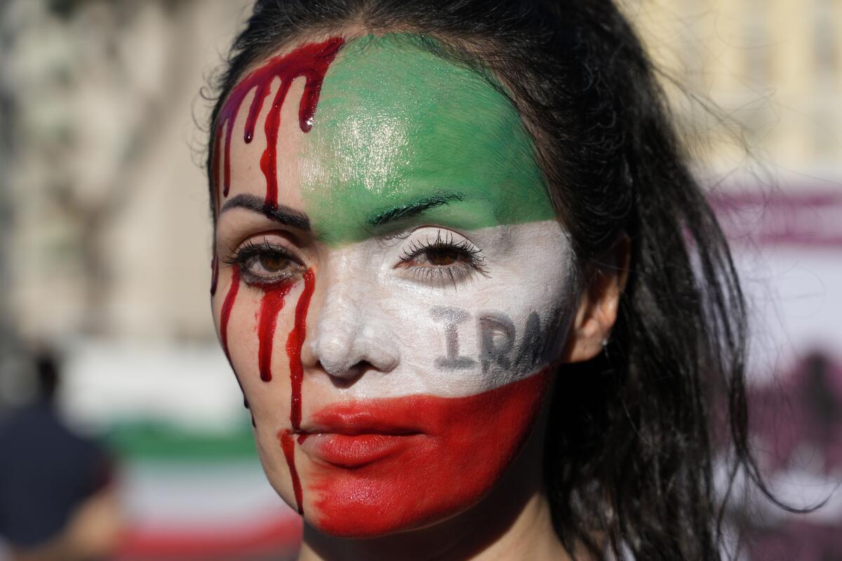 Woman with a painted face at a protest against the death of Mahsa Amini