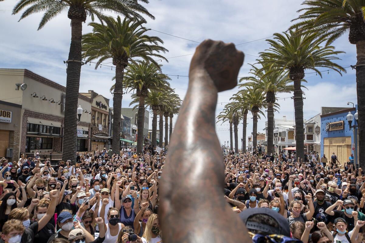 Black Lives Matter protesters take a knee and raise their fists during a moment of silence to honor George Floyd.