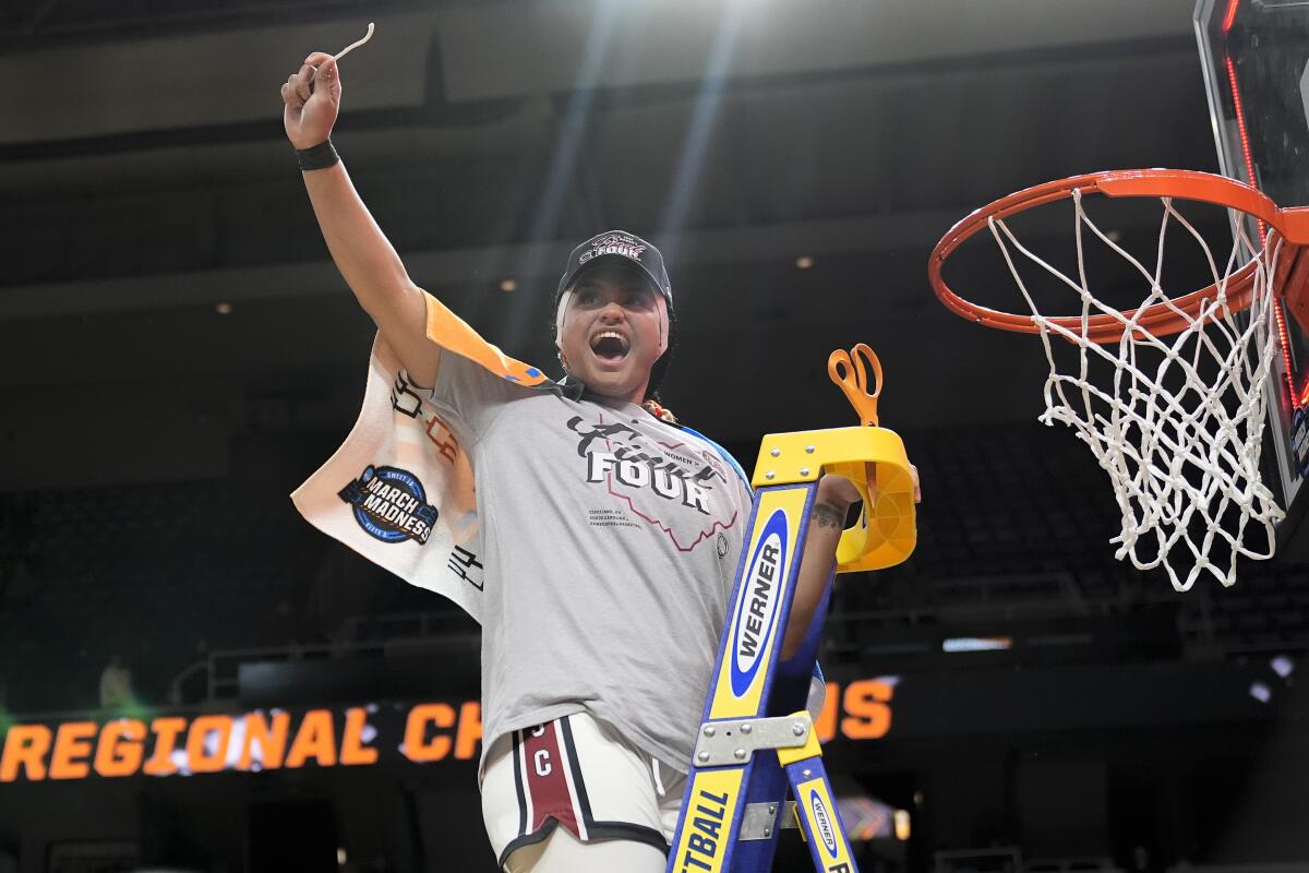 South Carolina guard Te-Hina Paopao (0) holds up a piece of the net after defeating Oregon State in the Elite Eight.