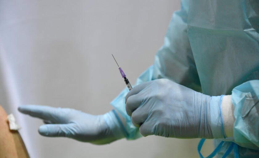 A health worker holds a syringe with the AstraZeneca vaccine against Covid-19 at a new vaccination centre at the former Tempelhof airport in Berlin, Germany, on Monday, March 8, 2021 (Tobias Schwarz / Pool via AP)