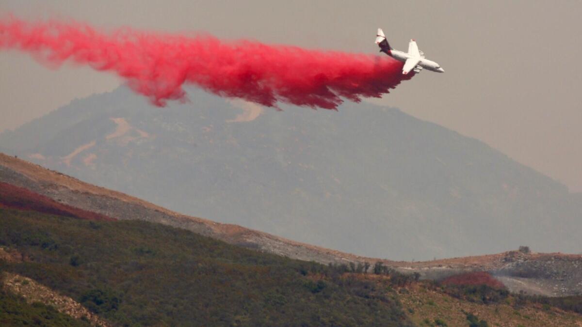 A plane drops fire retardant on the Whittier fire in Goleta on Saturday as firefighters on the ground employed controlled backfires along Camino Cielo in the Santa Ynez Mountains.