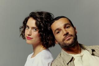Actors Margaret Qualley and Christopher Abbott pose for a portrait, leaning against each other.