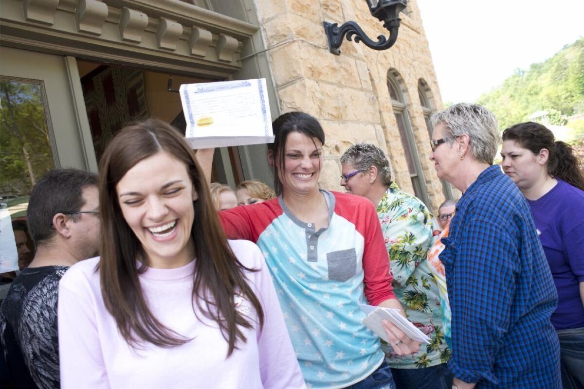 A lesbian couple in Arkansas show off their marriage certificate over the weekend.