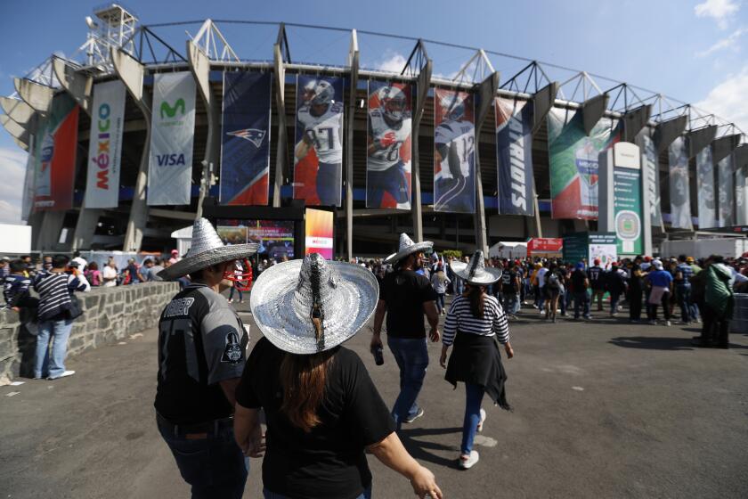 FILE - In this Nov. 19, 2017, file photo, fans arrive at Azteca stadium before an NFL football game between the Oakland Raiders and the New England Patriots in Mexico City. The NFL is moving its five games scheduled for London and Mexico City this season back to U.S. stadiums because of the coronavirus pandemic, two people with knowledge of the switch told The Associated Press. All five regular-season games will be played at the stadiums of the host teams, the people said, speaking to the AP on condition of anonymity Monday, May 4, 2020, because the decision has not been announced publicly.(AP Photo/Eduardo Verdugo, File)