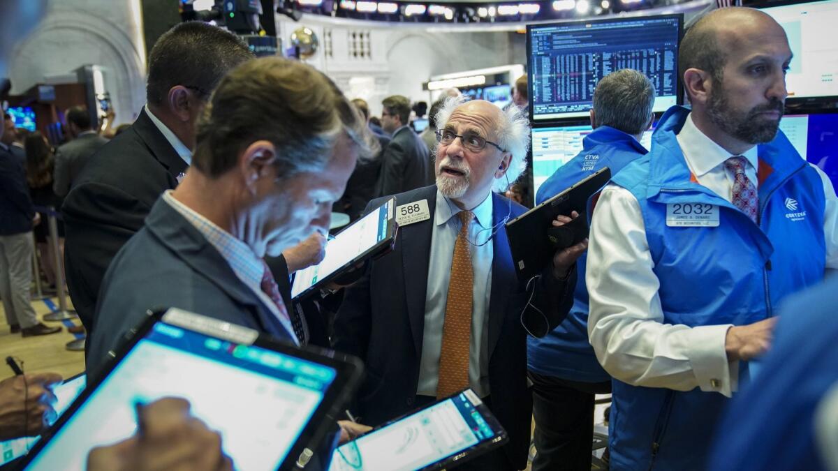 Traders and financial professionals work at the opening bell on the floor of the New York Stock Exchange on June 3.