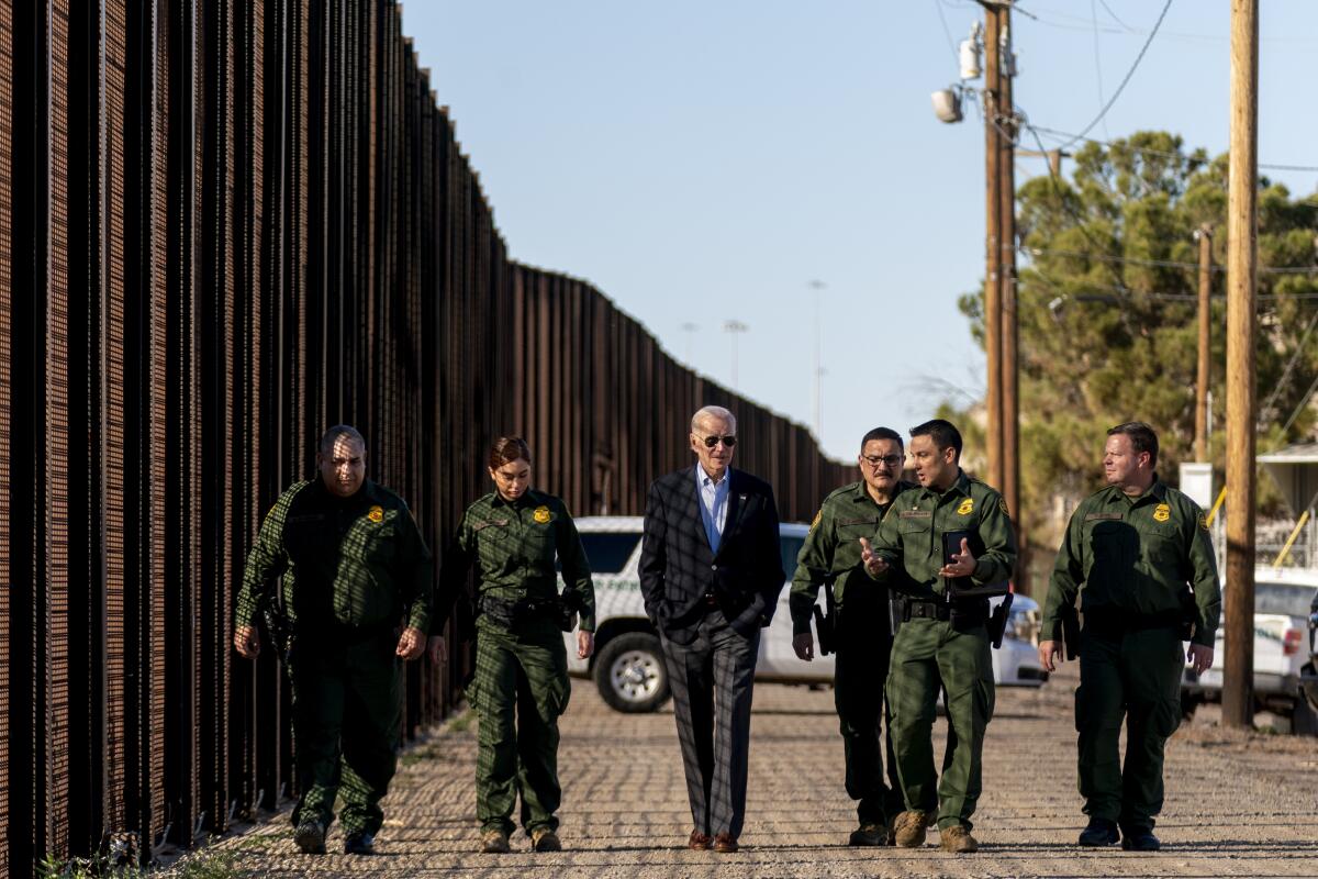 ARCHIVO - El presidente estadounidense Joe Biden camina junto con agentes de la Patrulla Fronteriza 