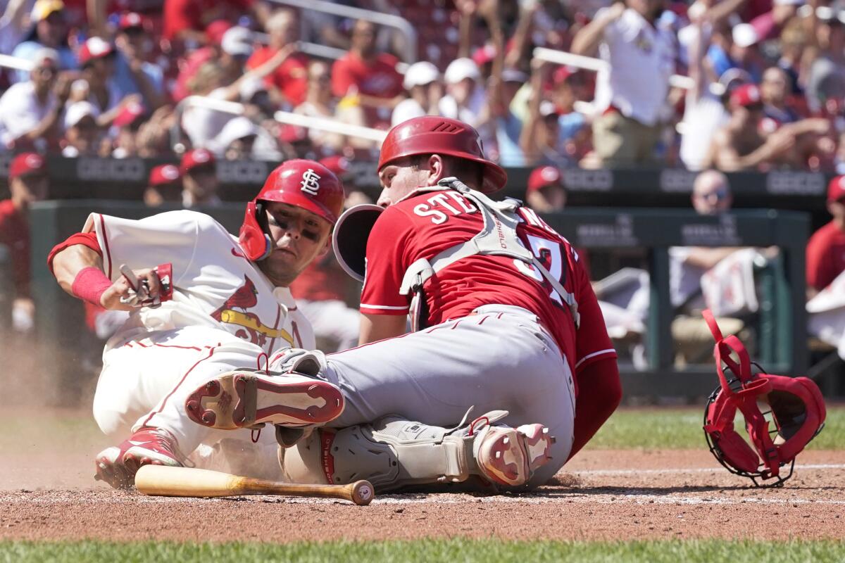 St. Louis Cardinals' Lars Nootbaar, left, scores past Cincinnati Reds catcher Tyler Stephenson during the seventh inning of a baseball game Saturday, July 16, 2022, in St. Louis. (AP Photo/Jeff Roberson)