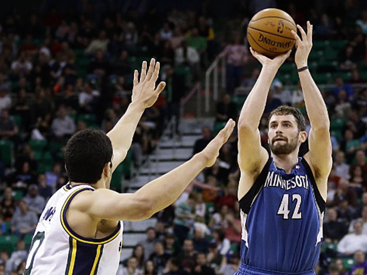 Minnesota's Kevin Love shoots over Utah's Enes Kanter on his way to his first career triple-double Saturday in Salt Lake City. (AP Photo/Rick Bowmer