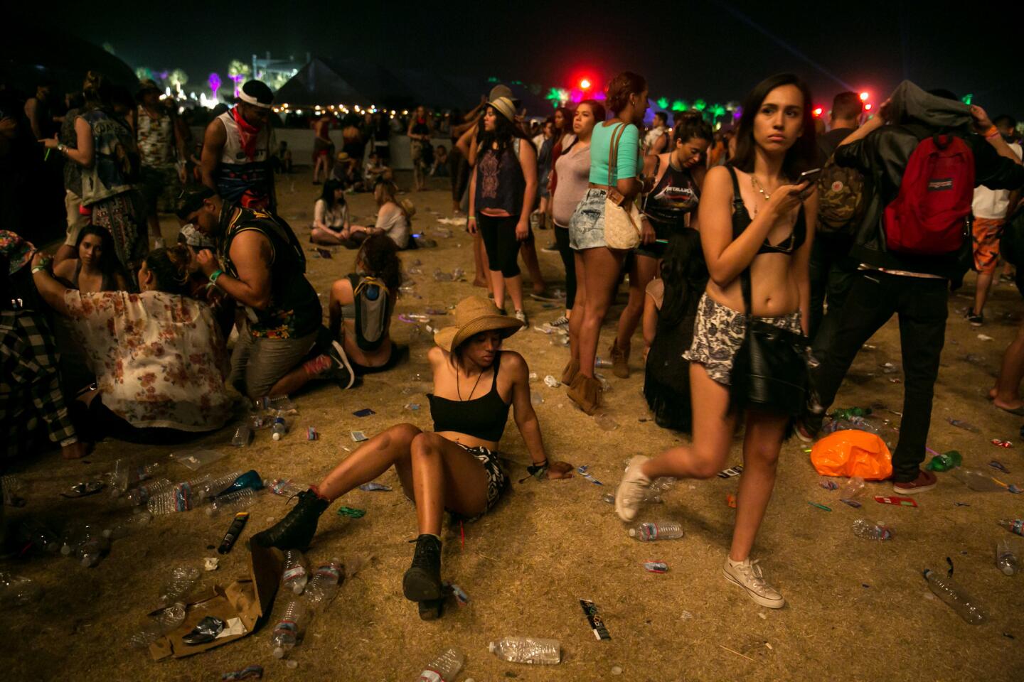 Music fans sit on the littered ground in disbelief at the abrupt ending to Drake's performance, 2015.