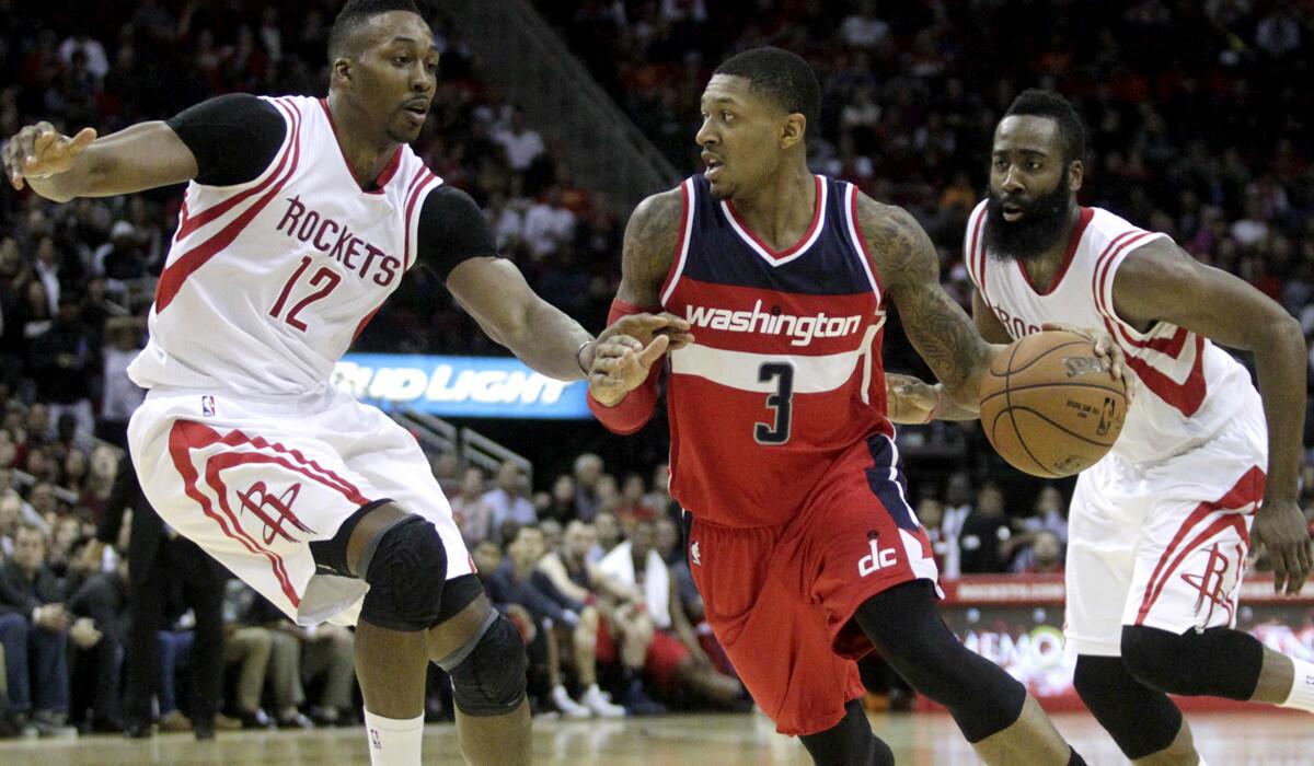 Rockets center Dwight Howard (12) and guard James Harden apply defensive pressure against Wizards guard Bradley Beal (3) in the fourth quarter Monday night in Houston.