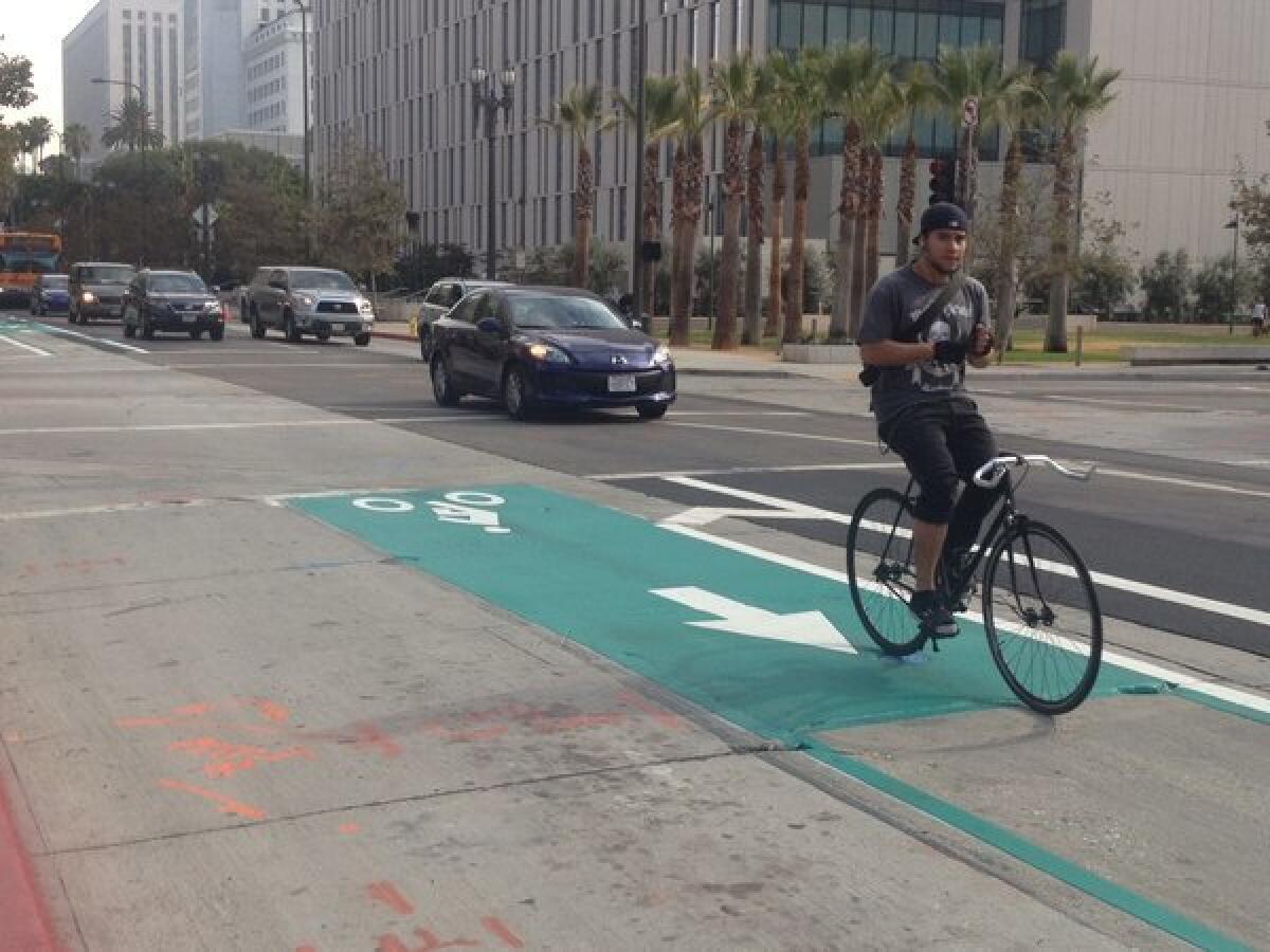 A bicyclist rides the new darker green bike lane on Spring Street south of 2nd Street in downtown Los Angeles.