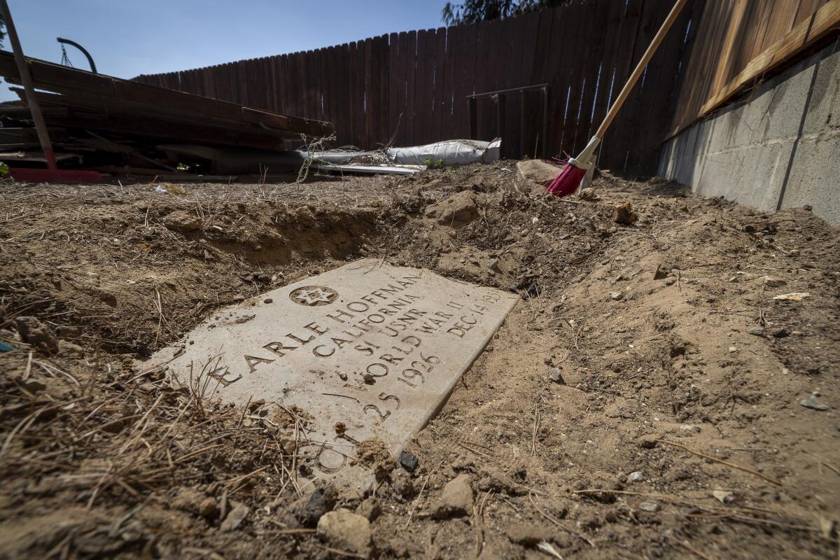 An uncovered headstone of WWII veteran Earle Hoffman is uncovered in the backyard of Josh Standifer's