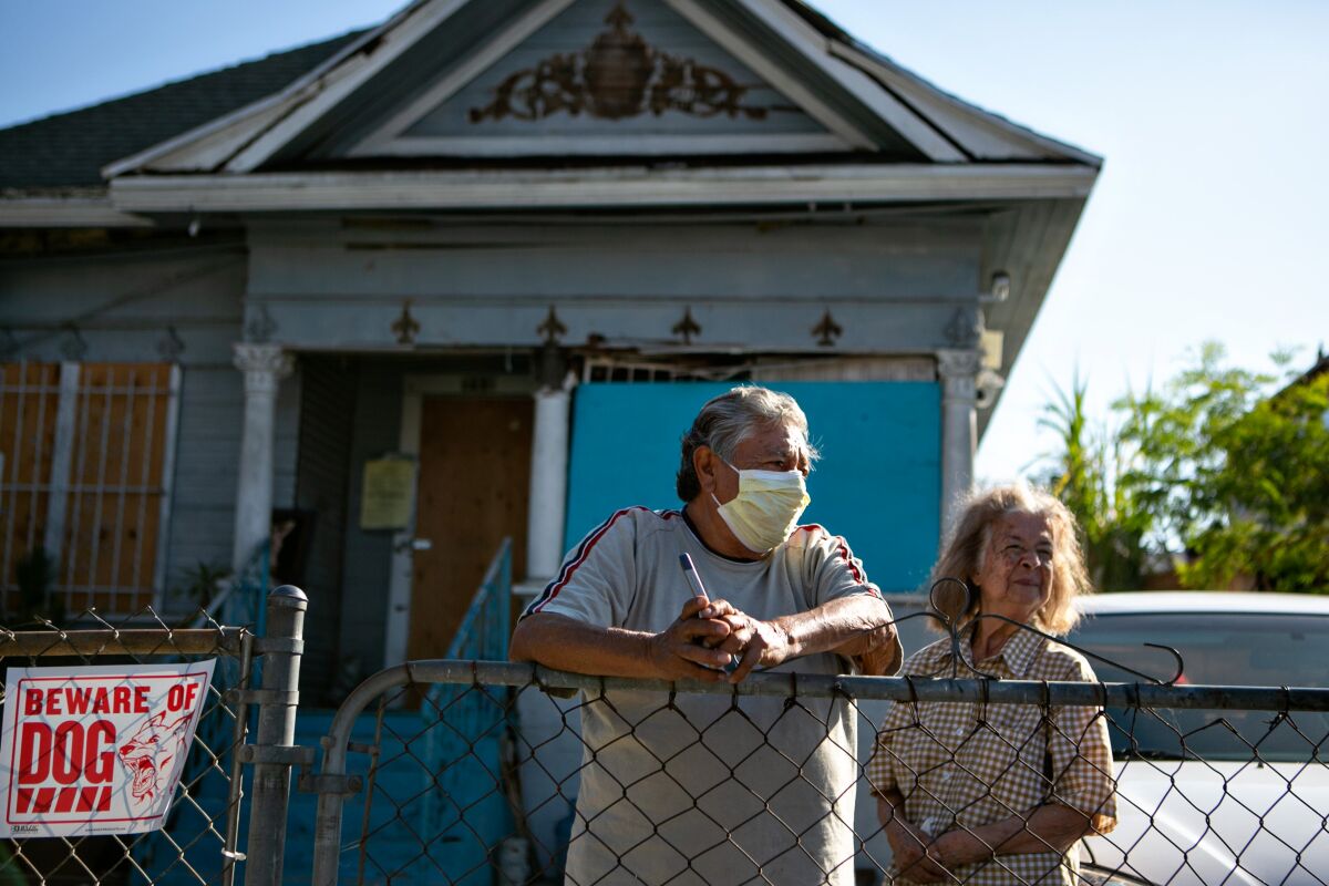 Candido Juarez and his wife stand in front of their homes that is uninhabitable after massive fireworks explosion June 30.