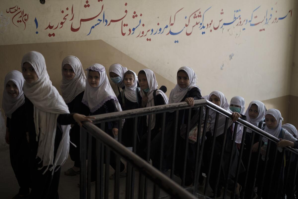 Girls walk upstairs as they enter a school before class in Kabul, Afghanistan, Sunday, Sept. 12, 2021. (AP Photo/Felipe Dana)
