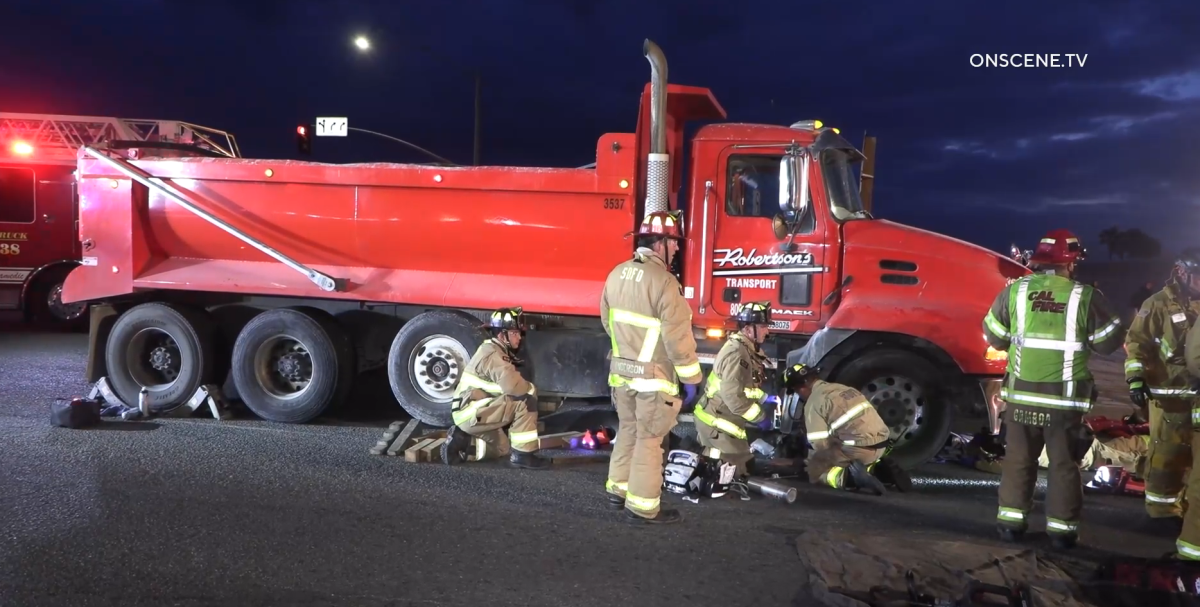 A bicyclist who ended up trapped underneath a commercial dump truck early Tuesday in Otay Mesa was rescued by firefighters.