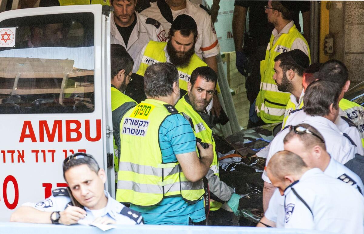 Israeli emergency services volunteers wheel into an ambulance the body of an Israeli who died during a stabbing attack in Tel Aviv on Thursday.