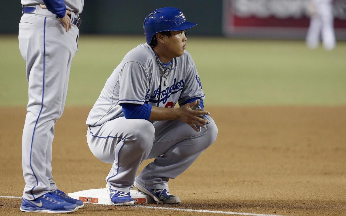 Pitcher Hyun-Jin Ryu squats at third base during the Dodgers' 2-1 loss in Arizona on Monday.