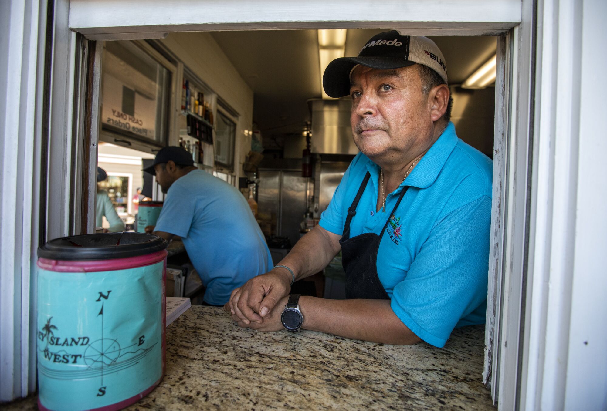 Alex Romero looks out the customer-service window of a restaurant