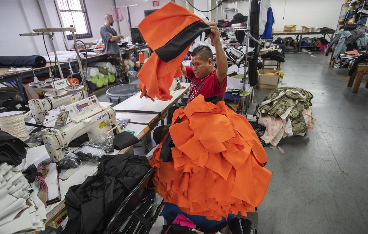 A garment worker places a jacket onto a pile in a factory in downtown Los Angeles. 