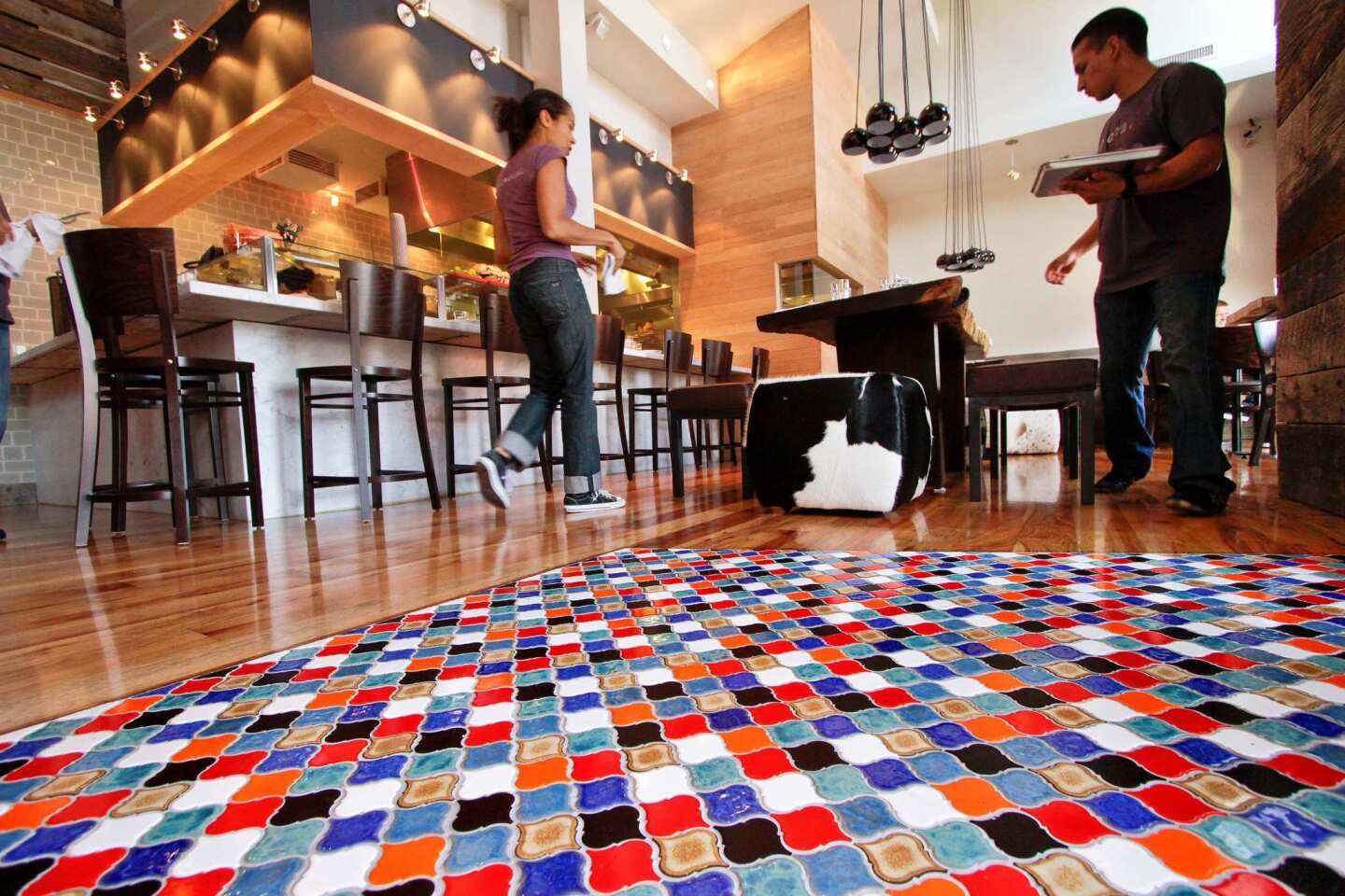 Colorful mosaic tile leads to a ceviche bar and the main dining room.