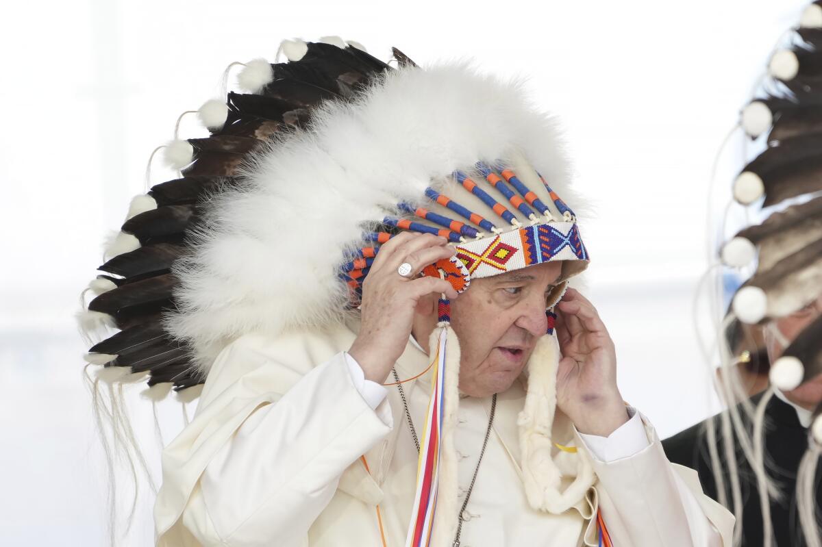 El papa Francisco se ajusta un tocado que le fue regalado después de ofrecer disculpas 