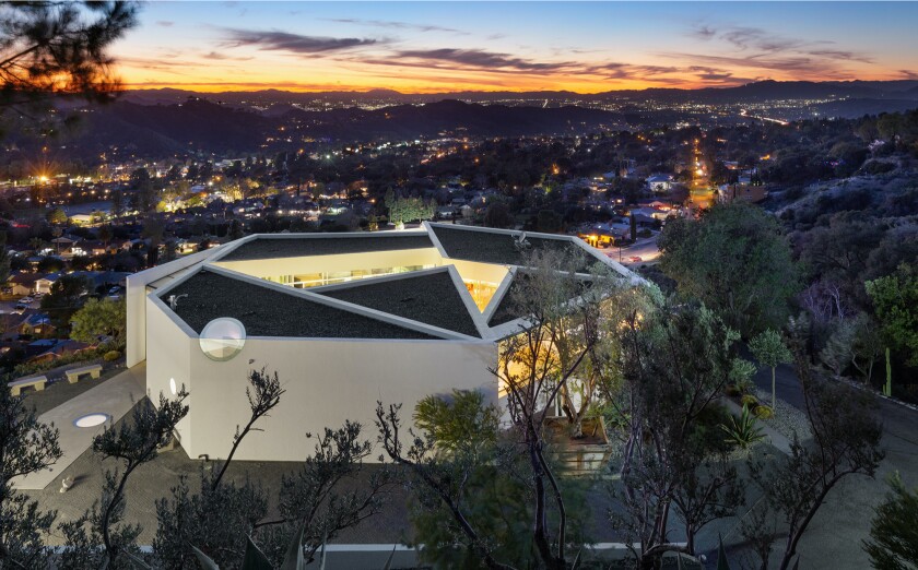 A futuristic building on a hillside.