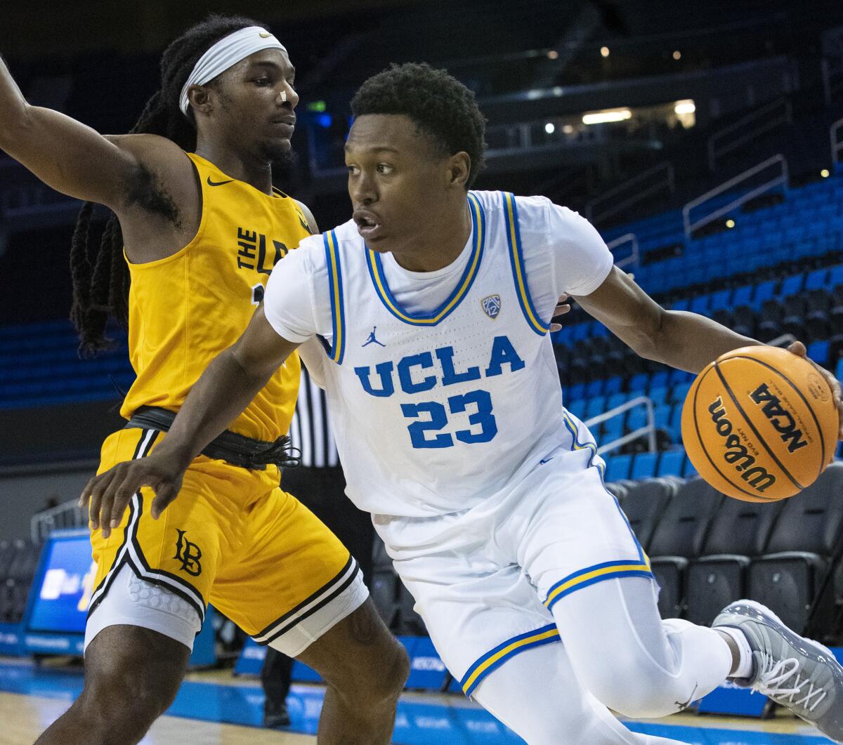 UCLA guard Peyton Watson drives past Long Beach State guard Colin Slater.