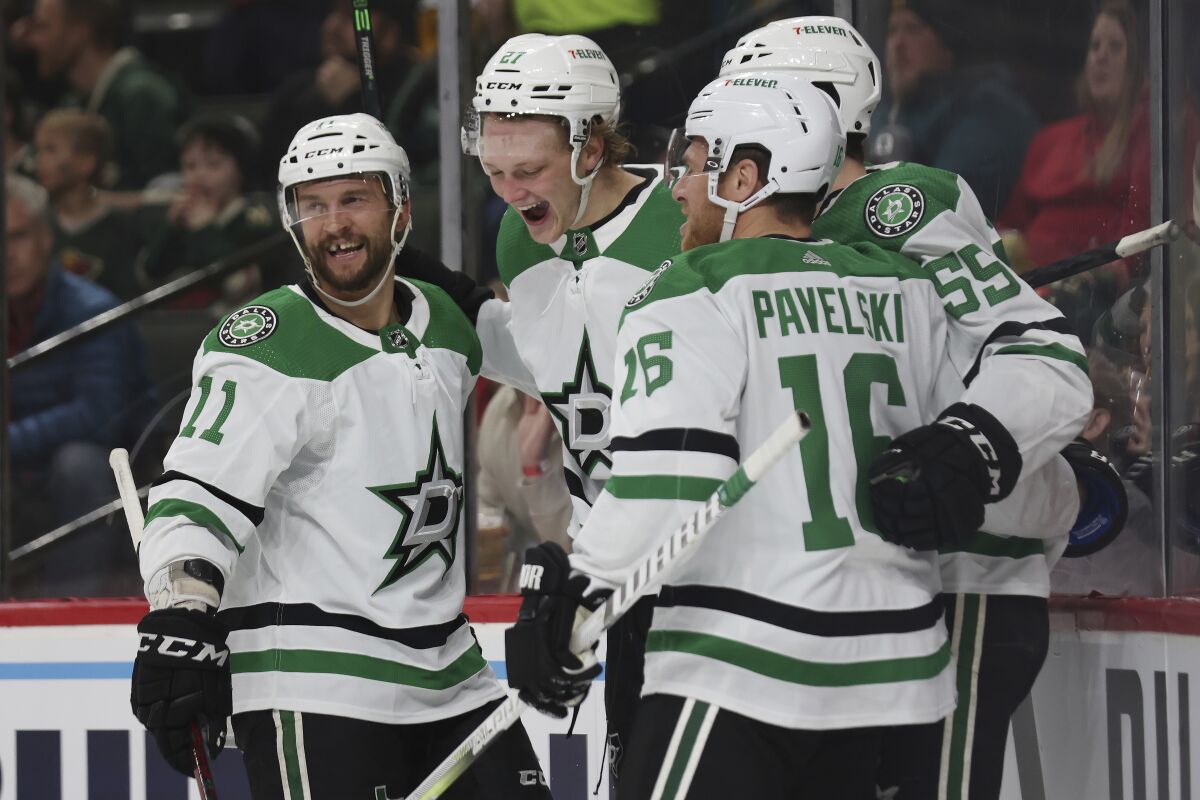Dallas Stars left wing Riley Tufte (27) reacts in celebration with teammates after scoring a goal against Minnesota Wild goaltender Kaapo Kahkonen during the second period of an NHL hockey game, Sunday, March 6, 2022, in St. Paul, Minn. (AP Photo/Stacy Bengs)