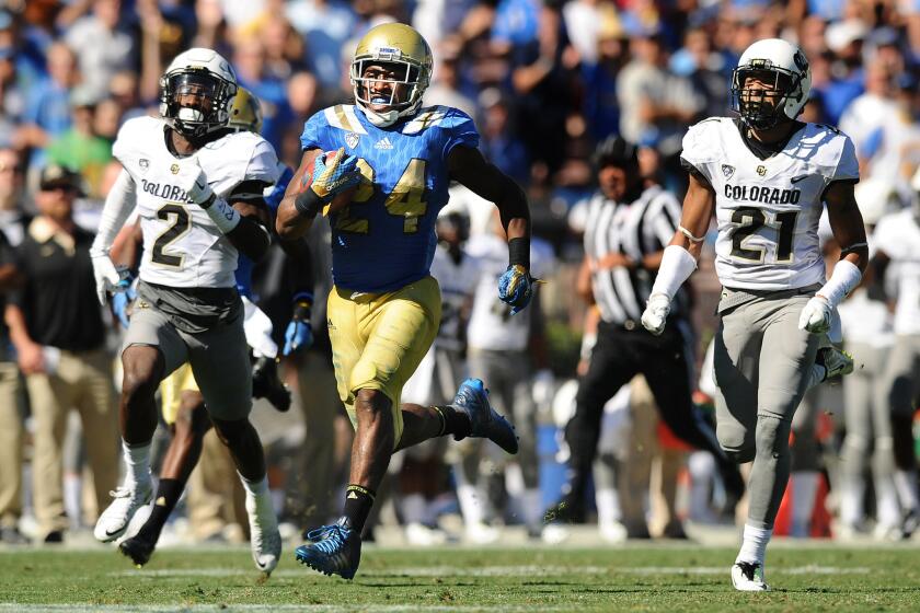 UCLA running back Paul Perkins outruns Colorado's Ken Crawley (2) Jered Bell (21) for an 82-yard touchdown in the second quarter of a game at the Rose Bowl on Oct. 31.