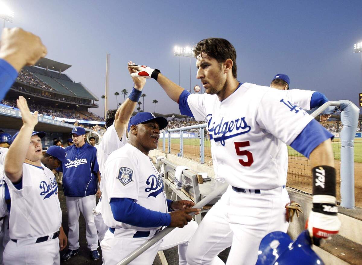 Los Angeles Dodgers' Nomar Garciaparra (5) is congratulated in the dugout after hitting a two-run home run against Atlanta Braves pitcher Jorge Campillo to score teammate James Loney during the fifth inning of a baseball game at Dodger Stadium in Los Angeles, Monday, July 7, 2008.