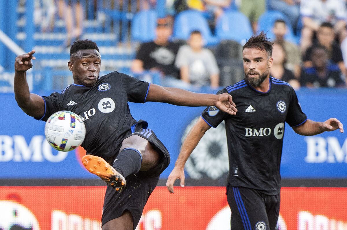 CF Montreal's Victor Wanyama takes a shot on goal as Rudy Camacho watches during the first half of the team's MLS soccer match against Toronto FC on Saturday, July 16, 2022, in Montreal. (Graham Hughes/The Canadian Press via AP)