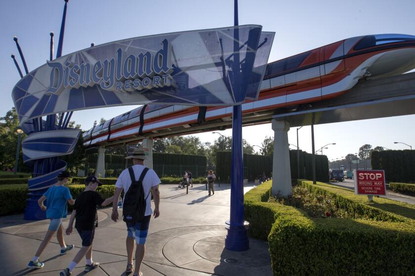 ANAHEIM, CALIF. -- WEDNESDAY, SEPT. 6, 2017: The Disneyland Monorail passes by as people walk under the Disneyland sign at the East Shuttle Area and South Harbor Boulevard in Anaheim Wednesday, Sept. 6, 2017. (Allen J. Schaben / Los Angeles Times)