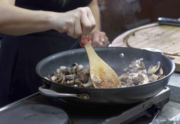 The Goldberg sisters cook mushrooms for the seitan Wellington they are making.