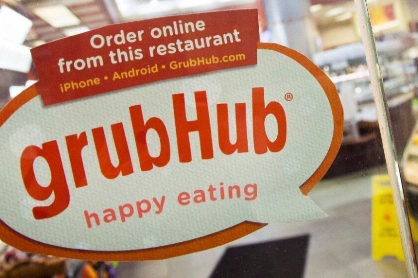 FILE - In this April 4, 2014 file photo, a sign for GrubHub is displayed on the door to a New York restaurant. The owner of KFC and Taco Bell, is teaming up with Grubhub to expand its delivery business. Yum Brands said Thursday, Feb. 8, 2018, that Grubhub will run KFC and Taco Bell delivery and online ordering in the United States. GrubHub will provide delivery people and its technology.(AP Photo/Mark Lennihan, File)
