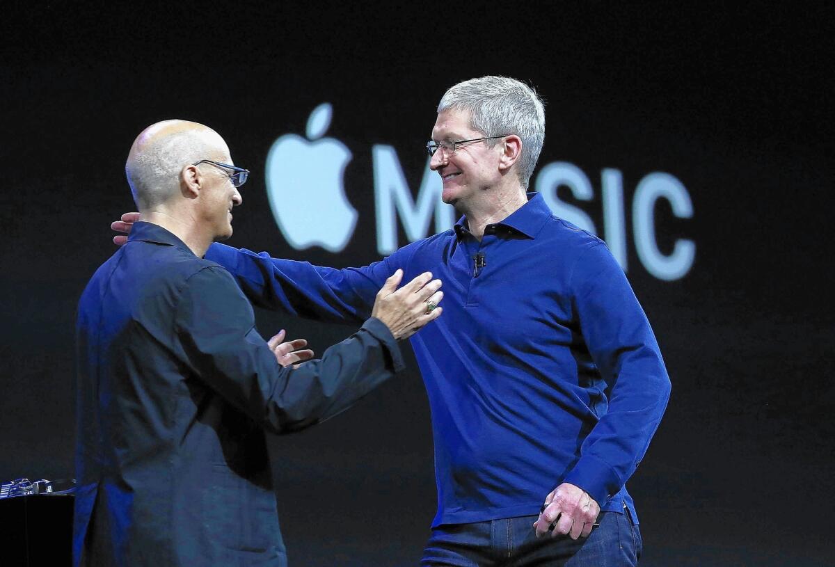 Apple CEO Tim Cook, right, greets Jimmy Iovine during the keynote address during Apple WWDC on June 8, 2015 in San Francisco.